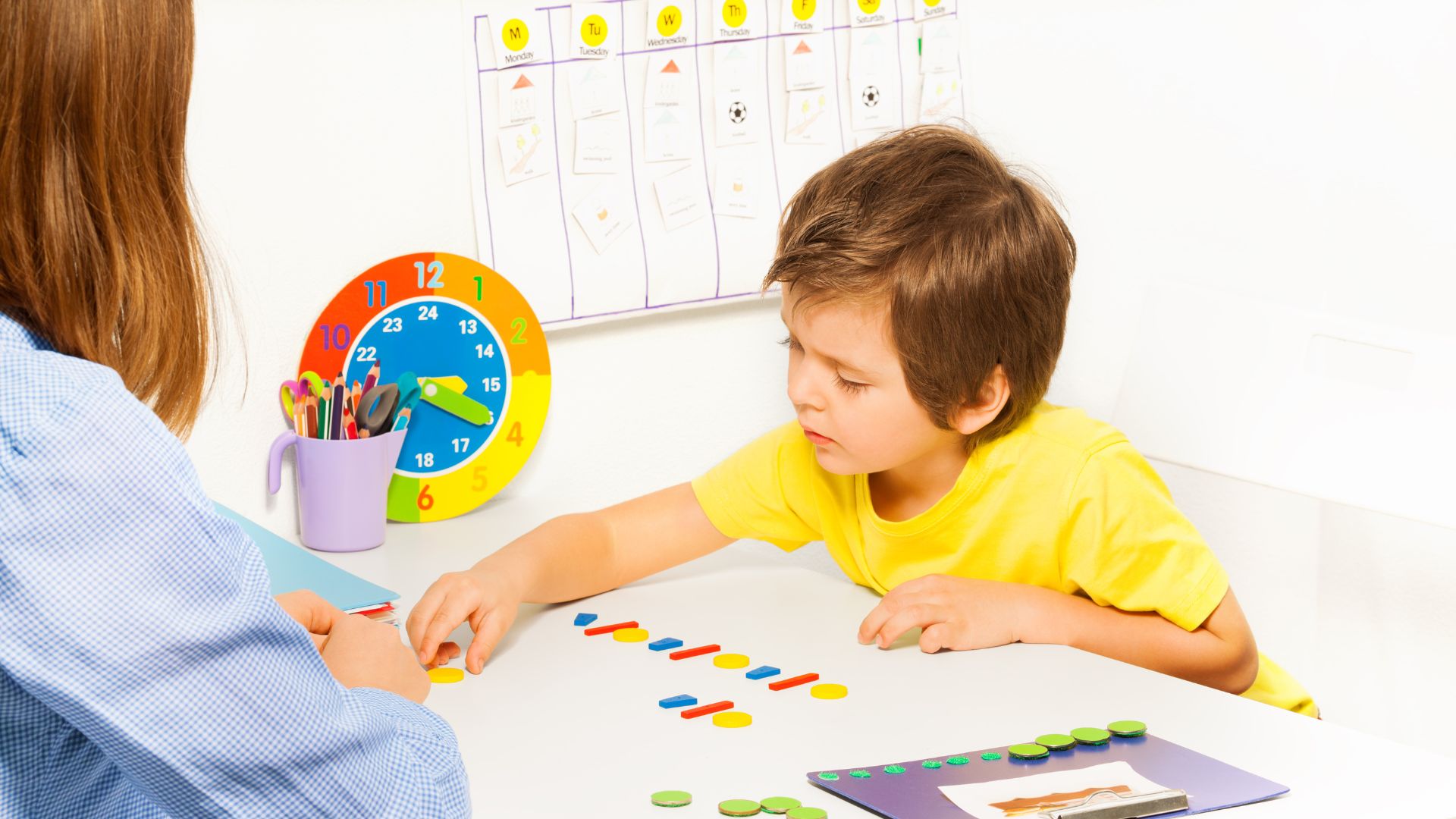 Criança em sessão de terapia com materiais educativos coloridos
